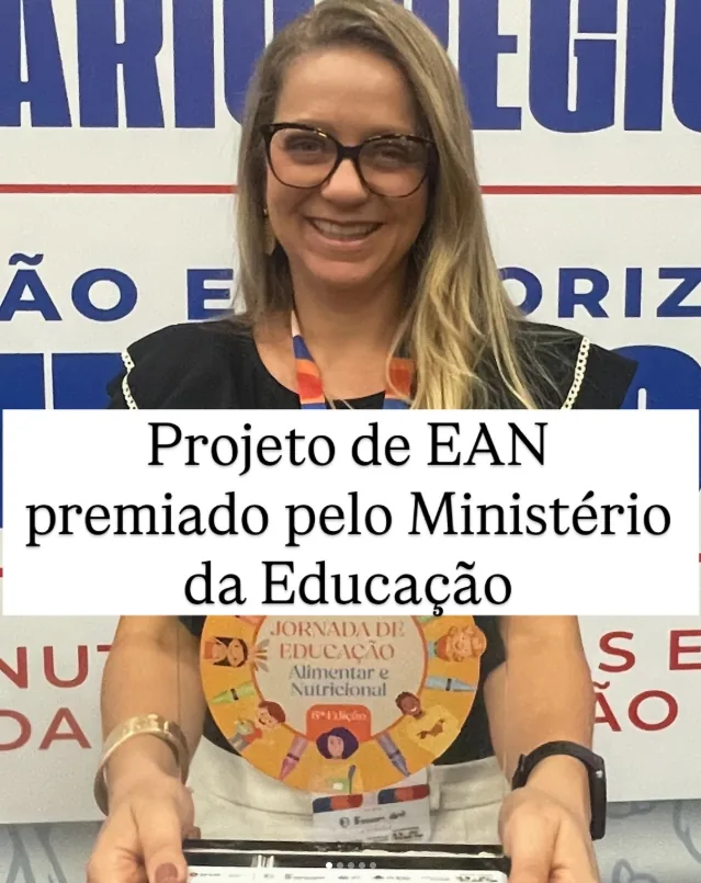 Maíra Ladeia segurando o prêmio recebido pelo projeto de Educação Alimentar e Nutricional